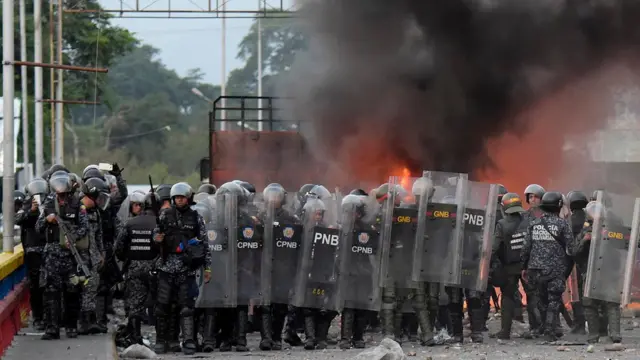 Pasukan keamanan Venezuela di depan sebuah truk berisi bantuan AS yang dibakar saat mencoba masuk ke dalam area Venezuela