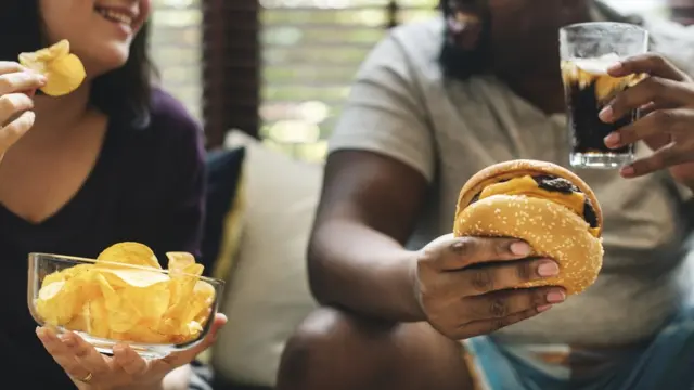 Pessoas comendo batata frita e hamburguer