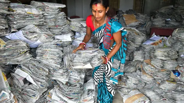 పేపర్లు మోసుకొస్తున్న యువతి