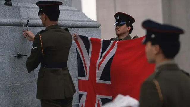 Soldiers take down the British flag in Statue Square, 1997 Hong Kong