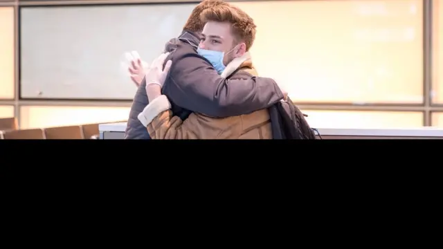 شخصان يتعانقان بأحد المطارات الأمريكية