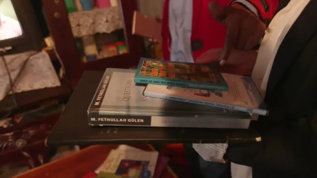 Huruma'da eski bir öğretmen, kendisine verilen Fethullah Gülen ve Said-i Nursi kitaplarını gösteriyor.