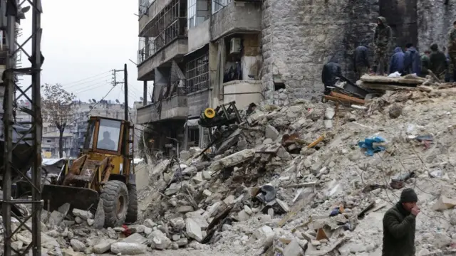 Sirios buscan víctimas y supervivientes entre los escombros de un edificio derrumbado en la ciudad de Alepo tras un terremoto mortal el 6 de febrero de 2023.