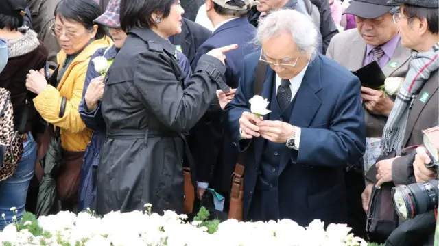 中枢纪念仪式结束后，许多民众排队献花，还有人低头啜泣。