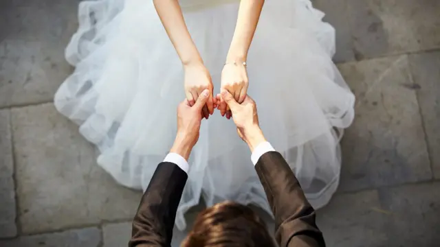 Mujer y hombre tomados de la mano