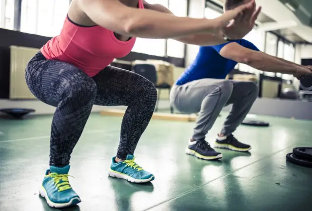Pareja haciendo sentadillas.