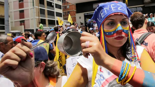 Una manifestante hace sonar una pequeza cacerola