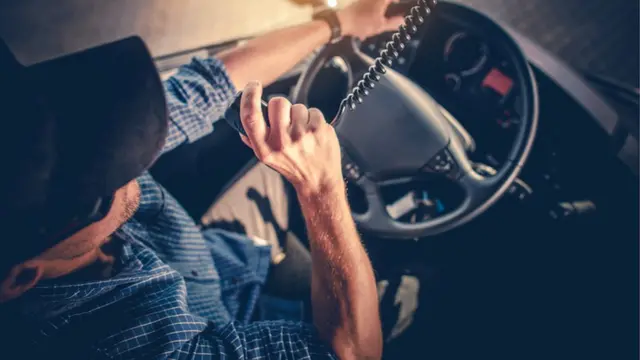 Camionero habla por un intercomunicador.