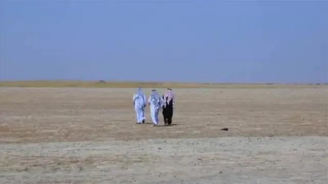 ثلاثة أشخاص يسيرون فوق بحيرة جافة