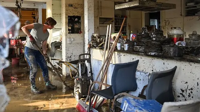 ఇళ్లలో బురద నిండిపోవడంతో వరద తగ్గిన తరువాత శుభ్రం చేసుకుంటున్న ప్రజలు