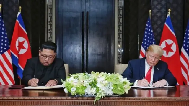 Kim Jong-un (kiri) dan Donald Trump menandatangani kesepakatan dalam pertemuan bersejarah di Singapura.