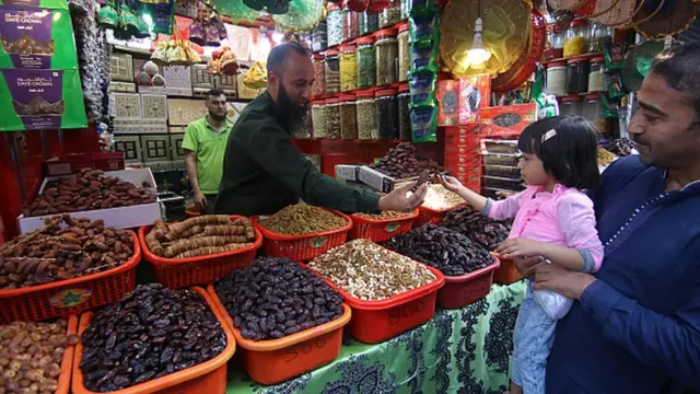 مردی هنگام فروش انواع خرما و میوه های خشک در اولین روز ماه مبارک رمضان در سرینگر کشمیر