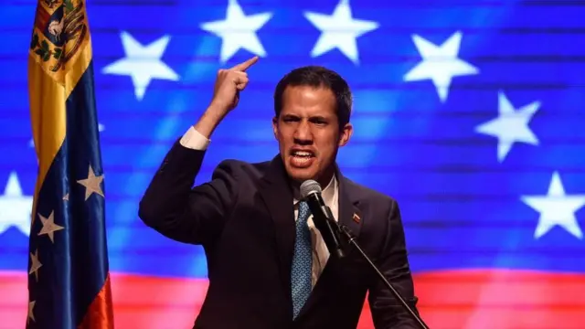 Juan Guaidó discursabet365 kasynofrente a projeçãobet365 kasynoimagem e bandeira da Venezuela