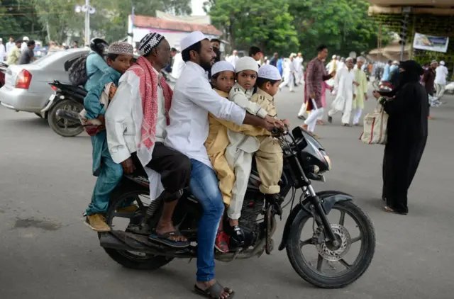 Berapa generasi India di sepeda motor ini -yang sedang menuju sebuah masjid di Hyderabad.