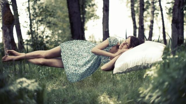 femme endormie, flottant sur une forêt