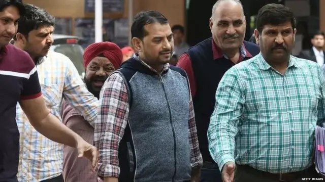 ग्रे जैकेट में पीएफ़आई के अध्यक्ष परवेज़ को गिरफ्तार कर ले जाती दिल्ली स्पेशल सेल