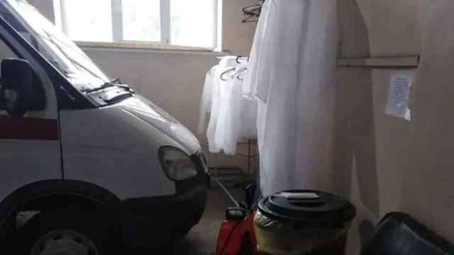 Постиранные одноразовые защитные костюмы сушатся в гараже подстанции скорой помощи