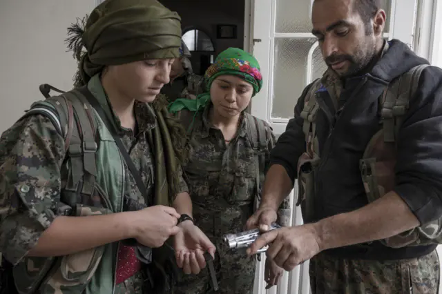 مرد مبارز کوبانی از زمان کوتاه پیش آمده جهت آموزش های حداقلی به زنان و دختران مبارز استفاده می کنند. نوامبر ۲۰۱۴