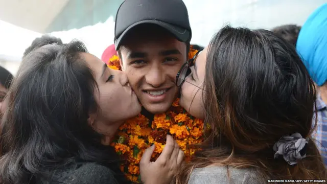 under19 cricketer Abhishek Sharma (C) is kissed by his sisters after arriving at Shri Guru Ram Das Ji International Airport in Amritsar on February 15,2018.