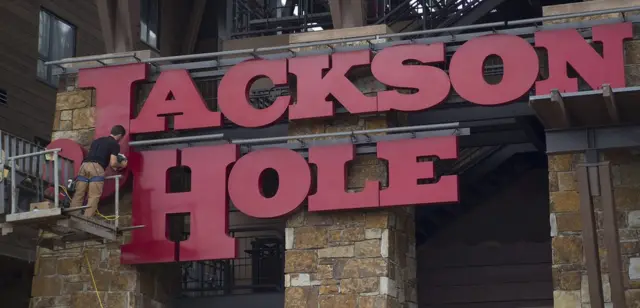 Un empleado ajusta el cartel del Jackson Hole Mountain Resort in Jackson, en Wyoming, Estados Unidos, el 13 de agosto de 2017.