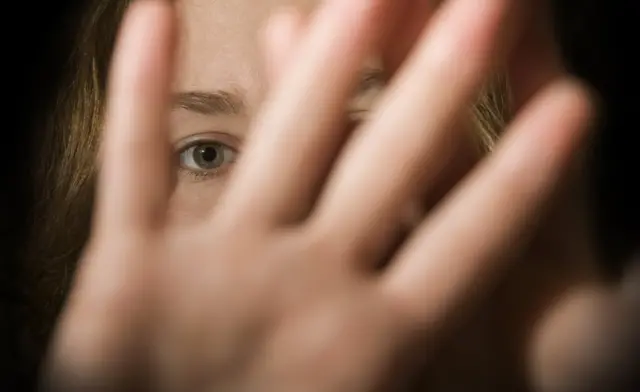 mujer se cubre la cara.