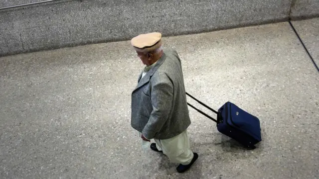 یک مسافر در لباس محلی در حال ترک فرودگاهی در واشنگتن