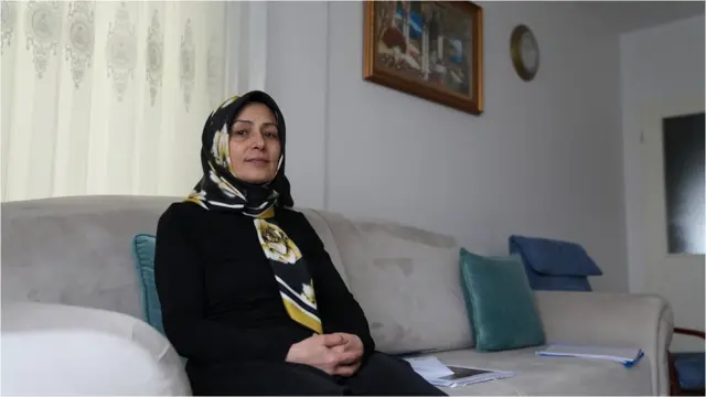 Nurgül Göksu sitting in her living room