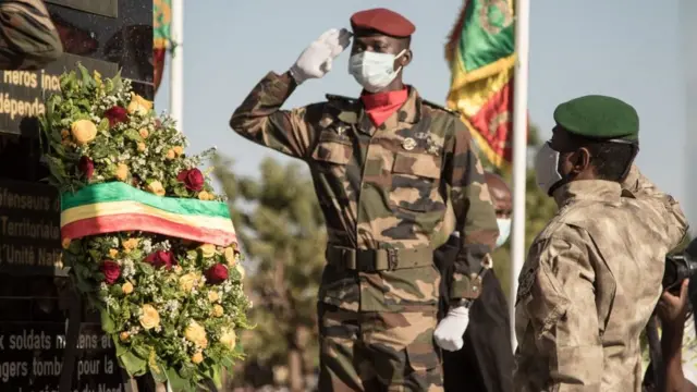 Le président malien de transition, le colonel Assimi Goïta (à droite), regarde après avoir déposé une gerbe sur le monument aux morts, lors de la cérémonie de célébration de la journée nationale de l'armée, à Kati, le 20 janvier 2022