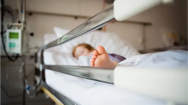 Un menor en una camilla de hospital.