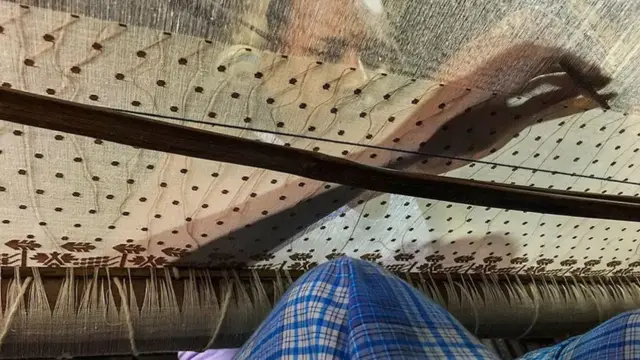 Un hombre teje muselina de Dhaka.