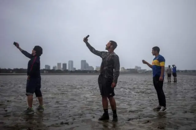 Jovens fazem self na areia da praia