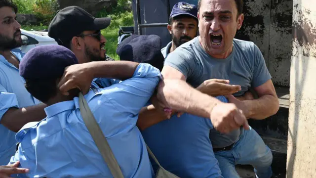 An emotional man is restrained