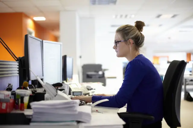 Mujer frenete a computador