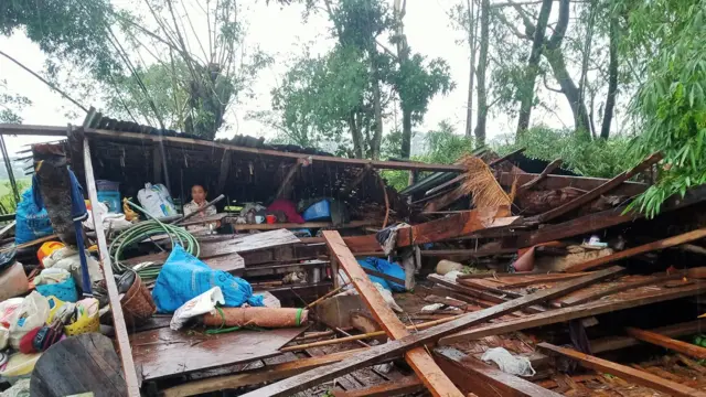 ပျက်စီးသွားတဲ့နေအိမ်နဲ့အတူ တွေ့ရတဲ့ လက်ပံတန်းဒေသခံ တစ်ဦး 