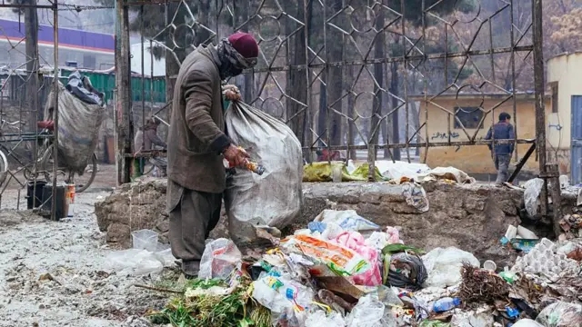 یو سړی په ډېران کې خواړه لټوي
