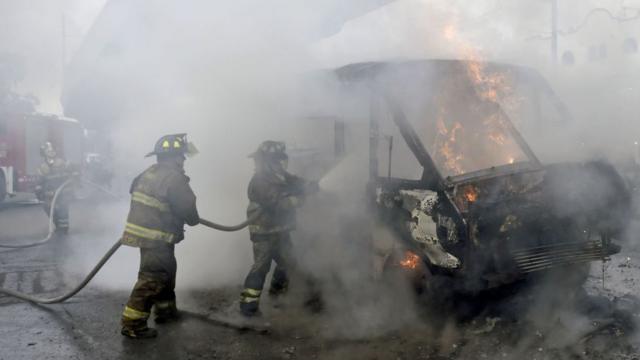 Bomberos apagan incendio en autobuses.