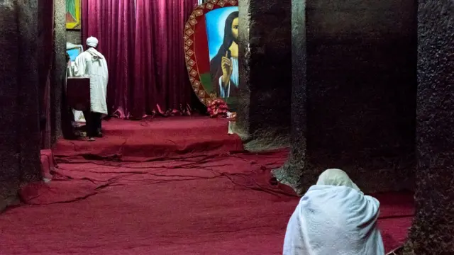 Внутри церкви: молящийся, священник и Иисус Христос