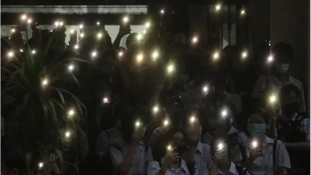 學生們打開手機閃光燈表示抗議。