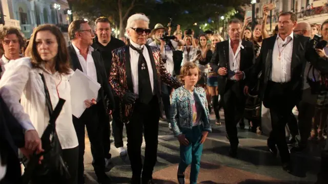 Karl Lagerfeld wey be head designer and creative director of fashion house Chanel, waka wit one model afta one fashion show of im latest inter-seasonal Cruise collection, for di Paseo del Prado street inside Havana, Cuba.