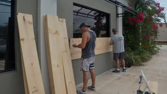 Evlerinin camlarını tahtalarla kapatan ABD'liler.