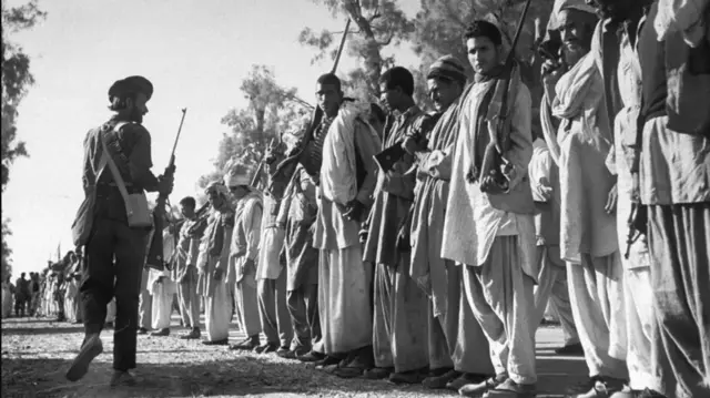 دا د ۱۹۴۷ کال انځور دی، چې پښتانه قبایل په کشمېر کې د هند پر وړاندي جګړه کې د برخې اخیستلو لپاره ګاډو او تجهزاتو ته په تمه دي‌. 