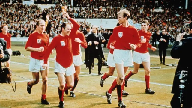 Jack Charlton observa a Ray Wilson posando la Copa Jules Rimet sobre su cabeza, mientras Bobby Charlton los sigue en la vuelta de honor en Wembley en 1966.