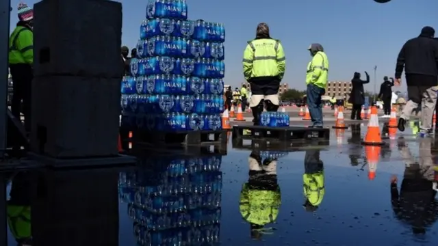 Workers in Houston pass out cases of water