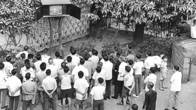 топтошкон кишилер короодо телевизор көрүп жатат