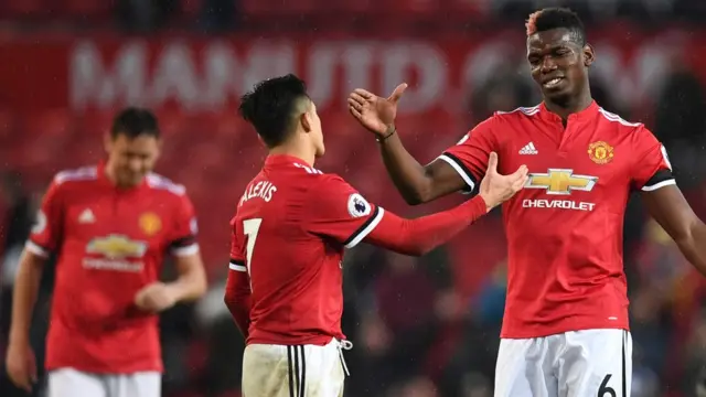 Manchester United's Chilean striker Alexis Sanchez (L) shakes hands with Manchester United's French midfielder Paul Pogba (R) at the end of the English Premier League football match between Manchester United and Huddersfield Town