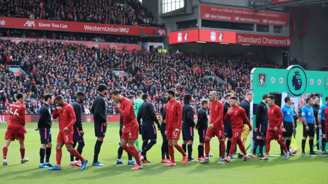 Players walk past eachother without shaking hands due to Coronavirus concerns before the Premier League match between Liverpool FC and AFC Bournemouth at Anfield on March 7, 2020 in Liverpool, United Kingdom.
