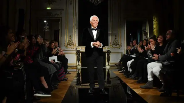 جورجو آرمانی در میان تشویق حاضران نمایش لباس‌های آرمانی در سال ۲۰۱۹ ایستاده است. 