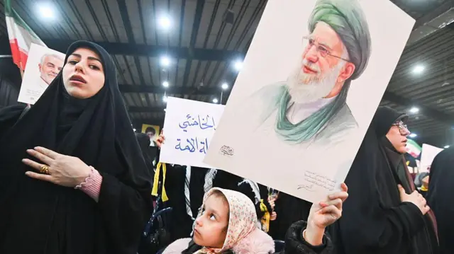 26 जनवरी 2026 को लेबनान के बेरूत में हुए एक प्रदर्शन में लोग हिज़्बुल्लाह के महासचिव नईम क़ासिम का भाषण सुनते हुए. दाहिये इलाक़े में लोग हिज़्बुल्लाह और ईरान के झंडे और ईरान के सर्वोच्च नेता आयतुल्लाह अली ख़ामेनेई के पोस्टर लेकर इकट्ठा हुए ताकि अमेरिकी राष्ट्रपति डोनाल्ड ट्रंप द्वारा घोषित ईरान पर संभावित अमेरिकी हमले के ख़िलाफ़ विरोध किया जा सके.
यह समूह ईरान के नेता अली ख़ामेनेई और ईरानी जनता के साथ एकजुटता जताने के लिए जुटा था.