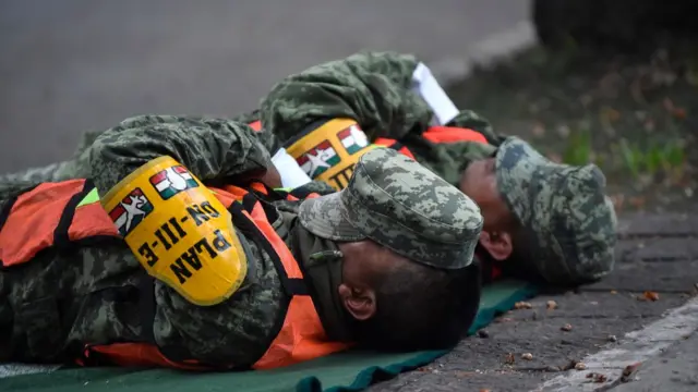 Rescatistas se toman un tiempo para descansar tras horas de trabajo.