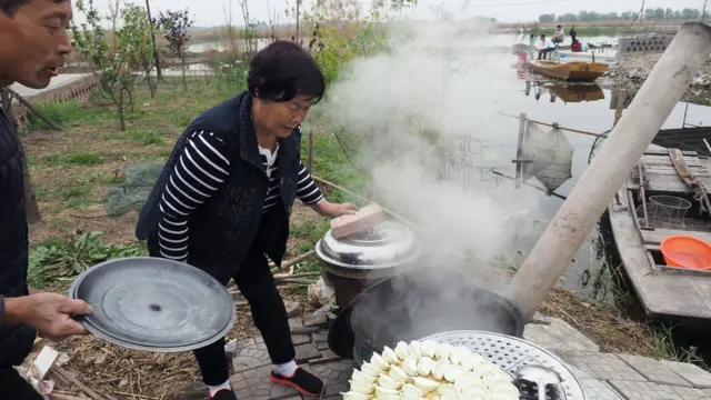 白洋淀的居民为住在家中的游客煮饺子。